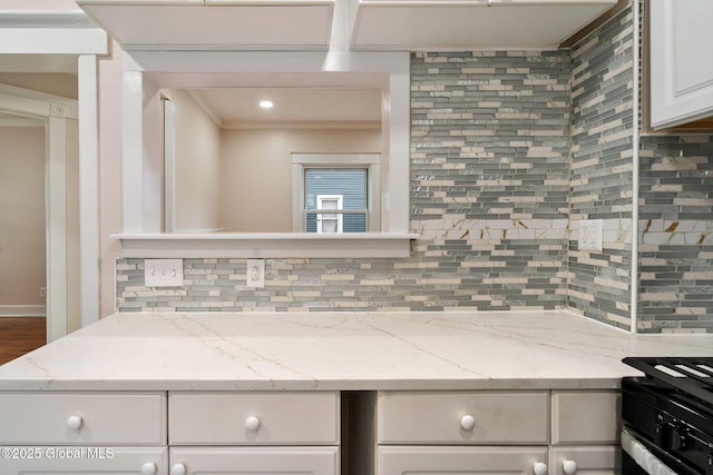 18 Bertha St, Albany, NY 12209 - kitchen with backsplash, light stone countertops, white cabinetry, and crown molding