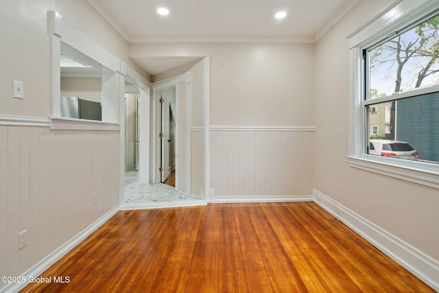 18 Bertha St, Albany, NY 12209 - empty room featuring crown molding, baseboards, a wainscoted wall, and wood finished floors