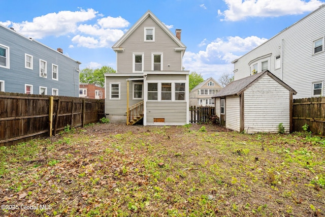 18 Bertha St, Albany, NY 12209 - back of house featuring a chimney, entry steps, an outbuilding, and a fenced backyard