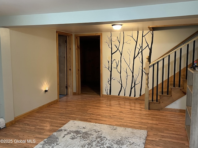 interior space featuring baseboards, stairs, and wood finished floors