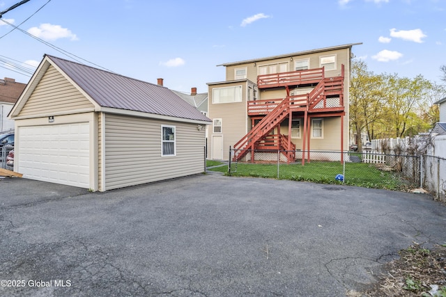 100 3rd St, Waterford, NY 12188 - rear view of property with fence, a detached garage, an outdoor structure, driveway, and metal roof