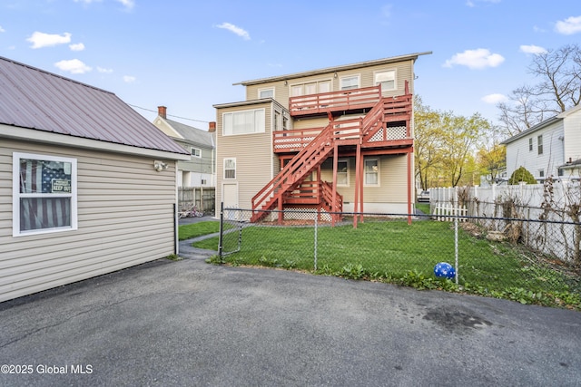 100 3rd St, Waterford, NY 12188 - back of house with a deck, a fenced backyard, metal roof, a lawn, and stairway