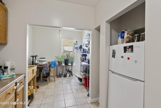 100 3rd St, Waterford, NY 12188 - kitchen with light tile patterned floors, freestanding refrigerator, and brown cabinetry