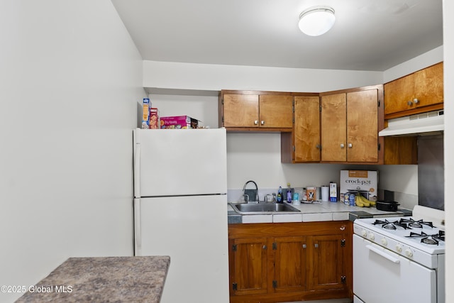 100 3rd St, Waterford, NY 12188 - kitchen featuring brown cabinets, a sink, white appliances, tile countertops, and under cabinet range hood