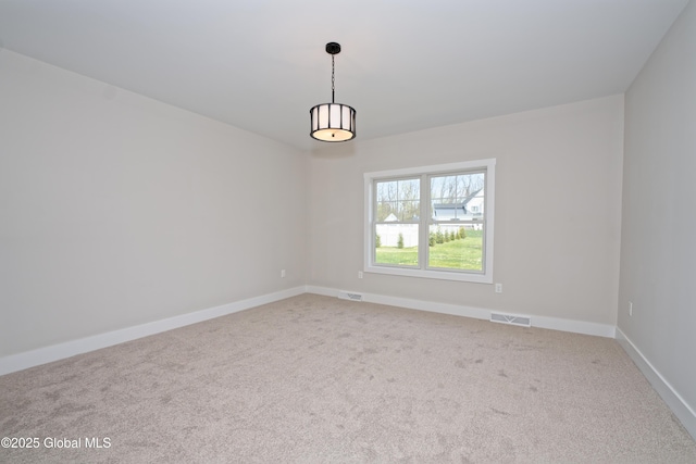 spare room featuring carpet floors, baseboards, and visible vents