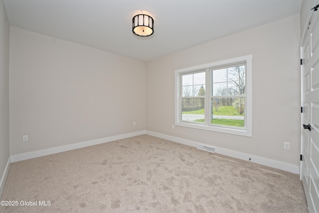 empty room featuring baseboards, carpet flooring, and visible vents