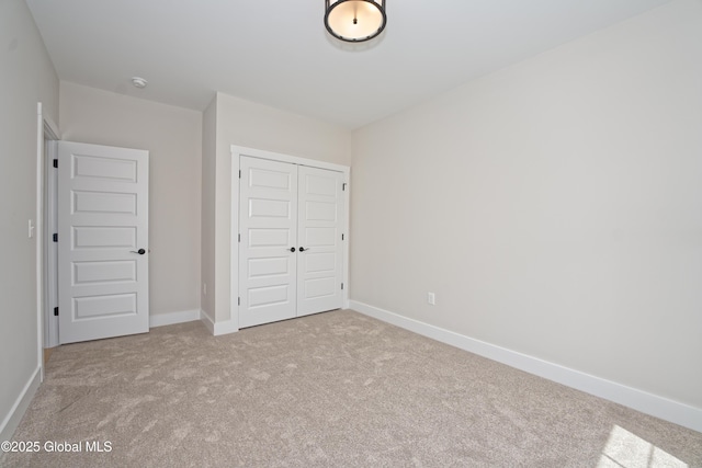 unfurnished bedroom featuring a closet, carpet flooring, and baseboards