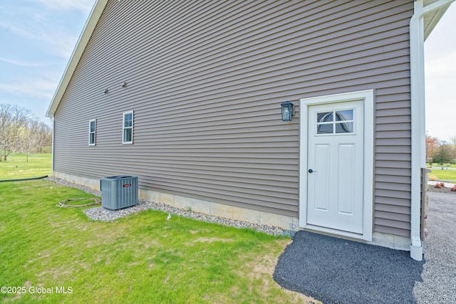 view of home's exterior with central AC unit and a yard