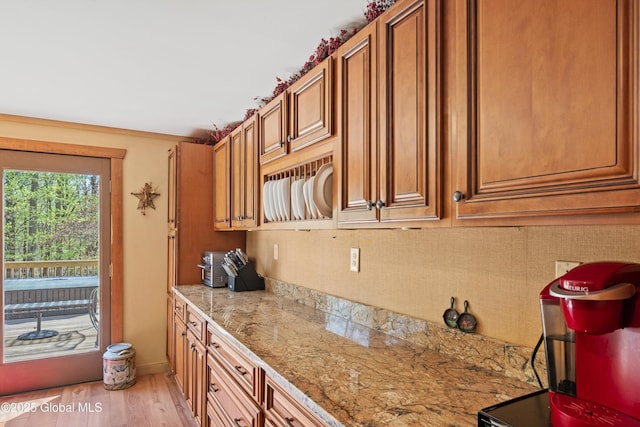3550 Boyhaven Rd, Middle Grove, NY 12850 - kitchen featuring backsplash, light stone counters, brown cabinetry, and light wood finished floors
