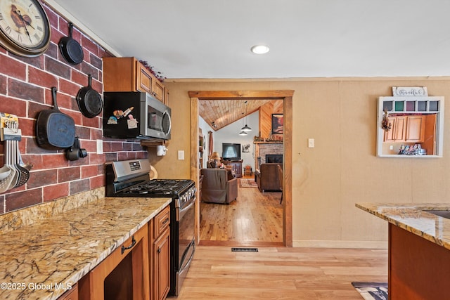 3550 Boyhaven Rd, Middle Grove, NY 12850 - kitchen with brown cabinets, appliances with stainless steel finishes, light stone counters, and light wood-style floors