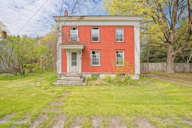 italianate home featuring fence and a front yard