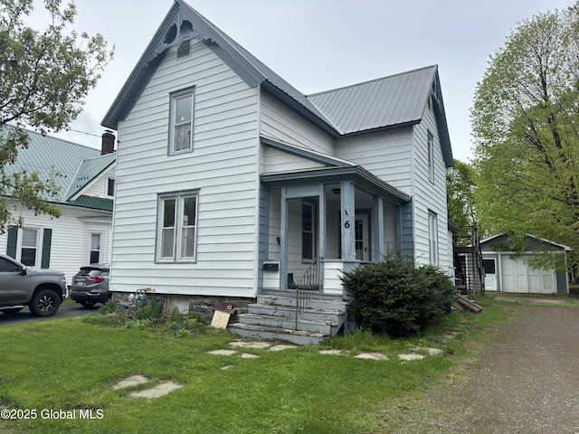 6 Cline St, Dolgeville, NY 13329 - traditional home with a front lawn, metal roof, an outdoor structure, and a porch