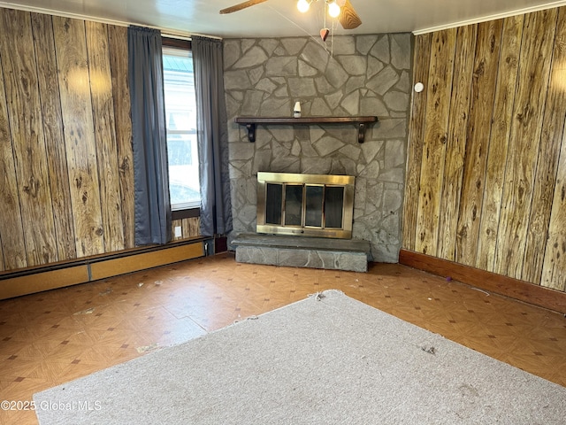 6 Cline St, Dolgeville, NY 13329 - unfurnished living room with ceiling fan, wood walls, a baseboard heating unit, and a stone fireplace