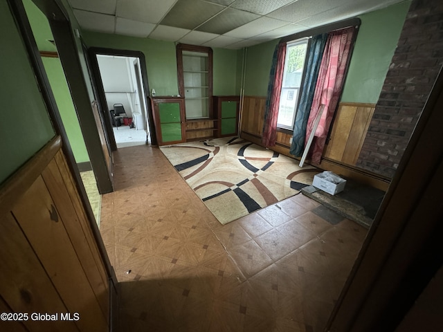 6 Cline St, Dolgeville, NY 13329 - miscellaneous room with tile patterned floors, a wainscoted wall, and a drop ceiling