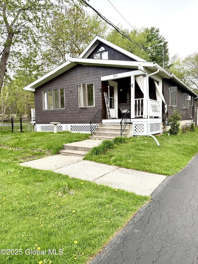bungalow-style home featuring covered porch and a front yard