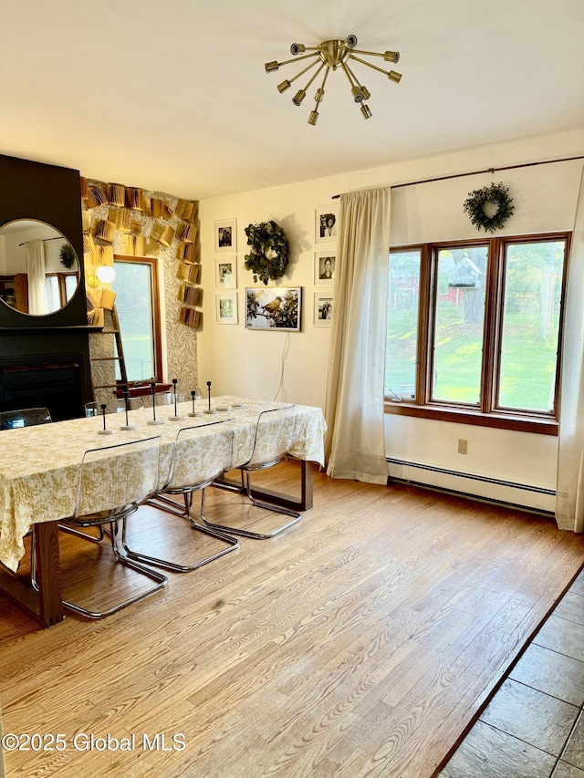 dining space with wood finished floors and a baseboard radiator