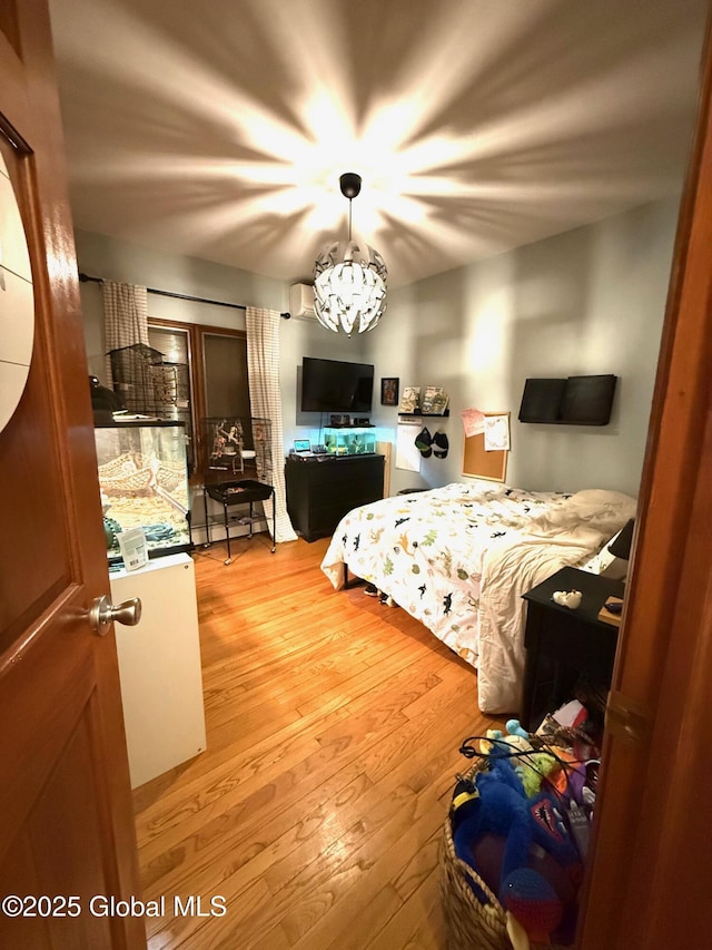 bedroom with light wood-style floors and a notable chandelier