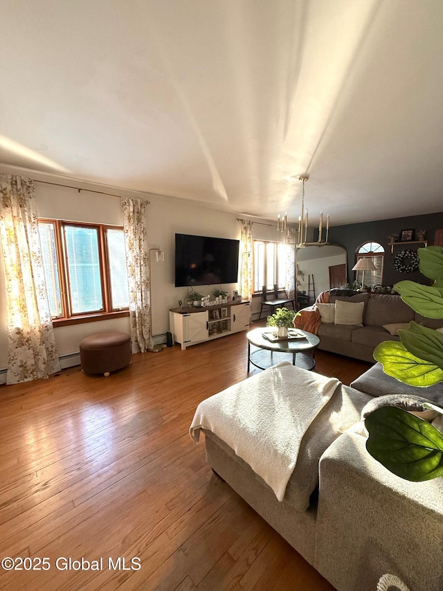 living room with a baseboard heating unit and hardwood / wood-style flooring