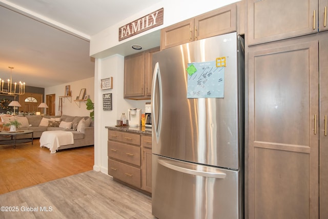 975 Riverview Rd, Schenectady, NY 12309 - kitchen featuring freestanding refrigerator, light wood-type flooring, a chandelier, open floor plan, and dark stone countertops