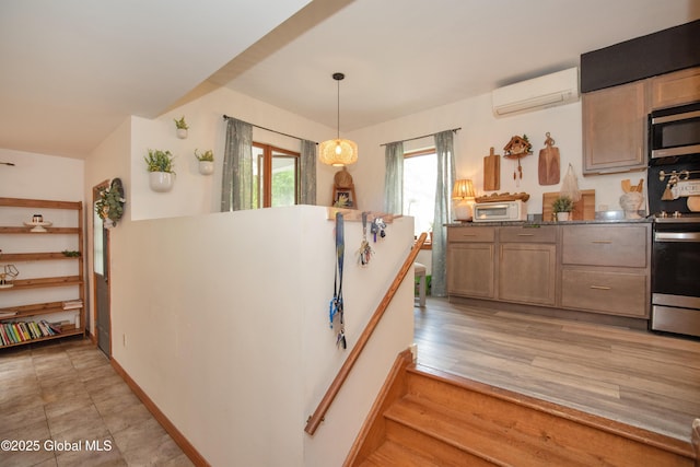 975 Riverview Rd, Schenectady, NY 12309 - kitchen with an AC wall unit, stainless steel microwave, and decorative light fixtures