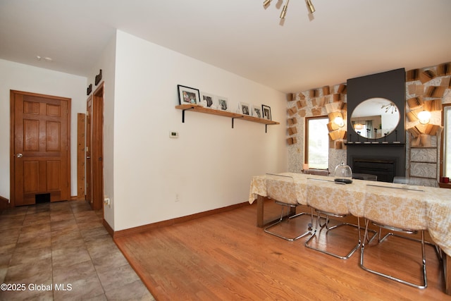 975 Riverview Rd, Schenectady, NY 12309 - kitchen with a fireplace, baseboards, a kitchen bar, open shelves, and light stone countertops