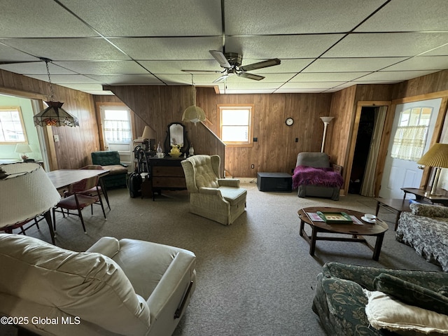 113 Forest Ave, Caroga, NY 12032 - carpeted living room featuring ceiling fan, a drop ceiling, and wooden walls
