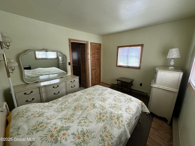 113 Forest Ave, Caroga, NY 12032 - bedroom with a closet, a baseboard heating unit, and dark wood-style flooring