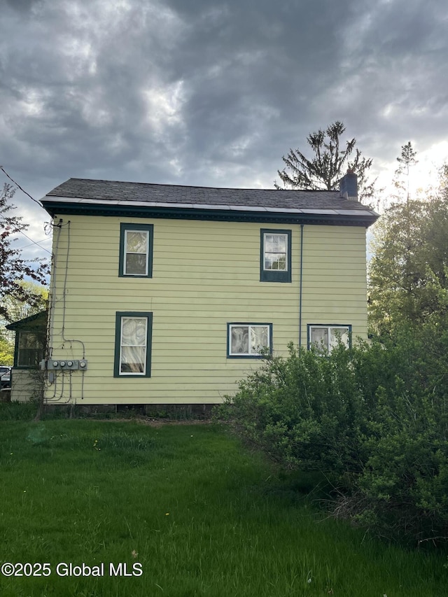 view of property exterior with a yard and a chimney