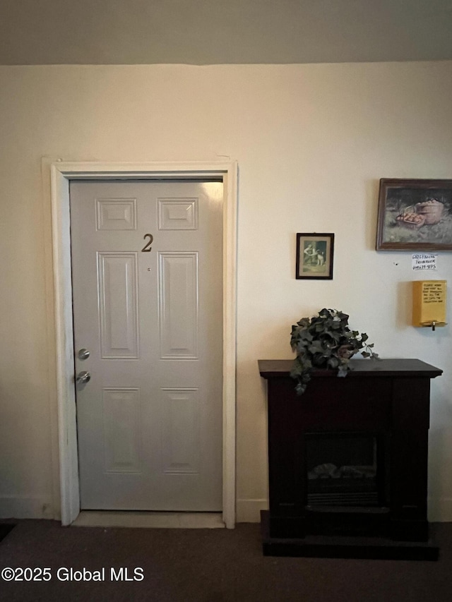 doorway featuring baseboards and a fireplace