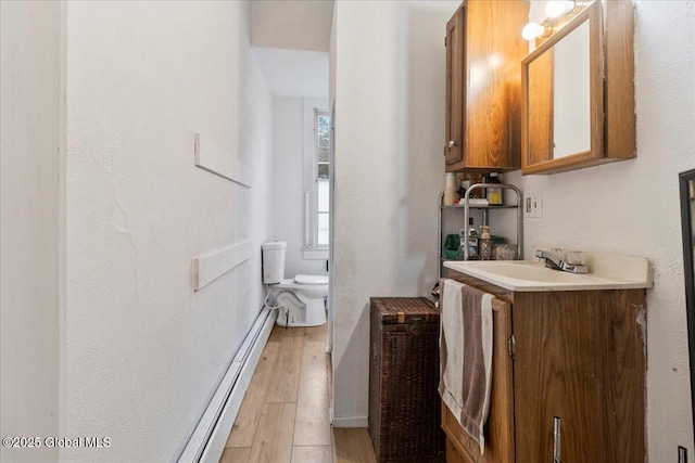 209 Lake Ave, Lake Luzerne, NY 12846 - bathroom with toilet, wood finished floors, baseboard heating, and vanity