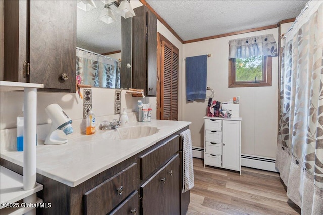 209 Lake Ave, Lake Luzerne, NY 12846 - bathroom featuring a textured ceiling, a baseboard heating unit, wood finished floors, and vanity