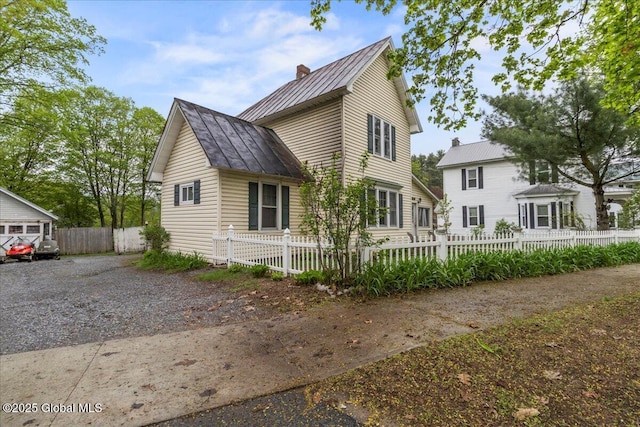 209 Lake Ave, Lake Luzerne, NY 12846 - view of home's exterior featuring a standing seam roof, metal roof, a chimney, and a fenced front yard
