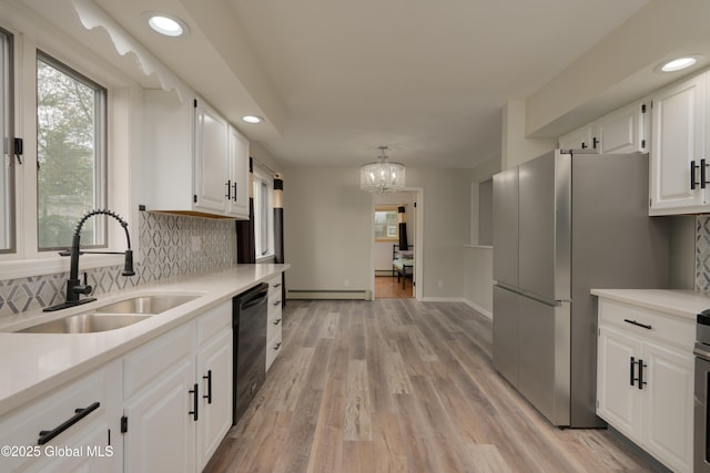 16 Van Heusen St, Colonie, NY 12205 - kitchen featuring black dishwasher, a sink, baseboard heating, tasteful backsplash, and light countertops