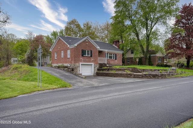 16 Van Heusen St, Colonie, NY 12205 - ranch-style home with driveway, brick siding, a garage, a chimney, and a front yard