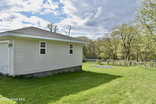 view of property exterior with a lawn, a garage, roof with shingles, and fence