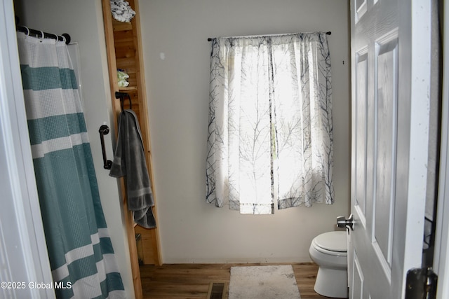 full bath featuring toilet, visible vents, plenty of natural light, and wood finished floors