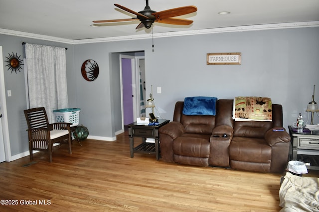 living room featuring ceiling fan, ornamental molding, baseboards, and light wood-type flooring