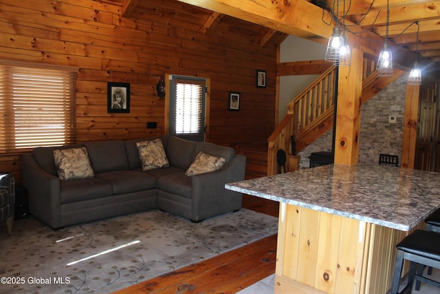 127 Fording Rd, Esperance, NY 12066 - living room featuring vaulted ceiling with beams, wood walls, stairs, and hardwood / wood-style floors