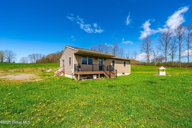 back of property with a wooden deck and a lawn