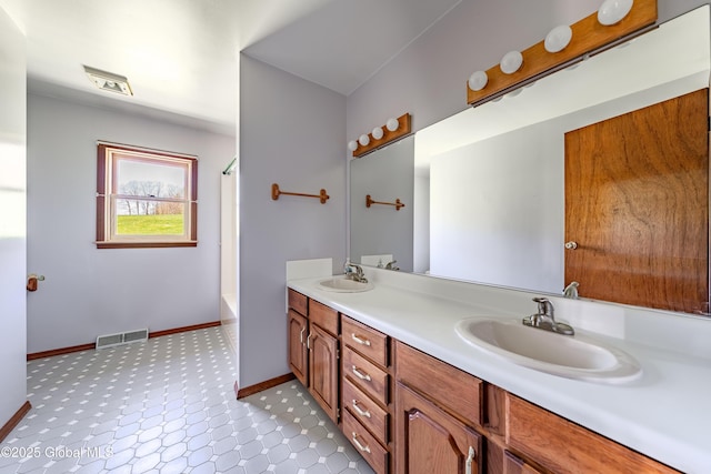 full bathroom with baseboards, visible vents, a sink, and double vanity