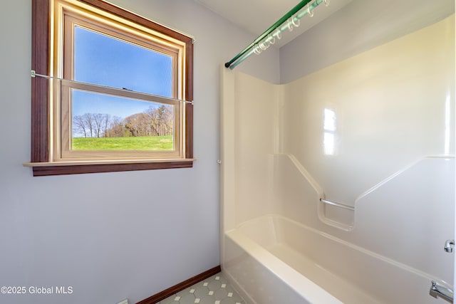 bathroom with shower / washtub combination and baseboards