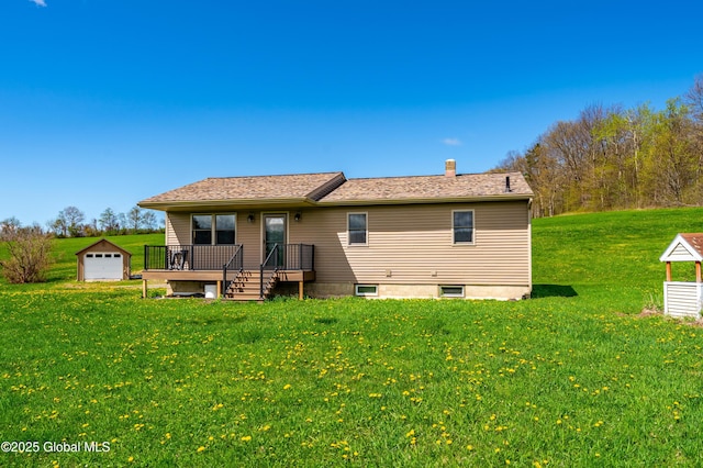 back of house with a lawn, a chimney, an outdoor structure, and a garage