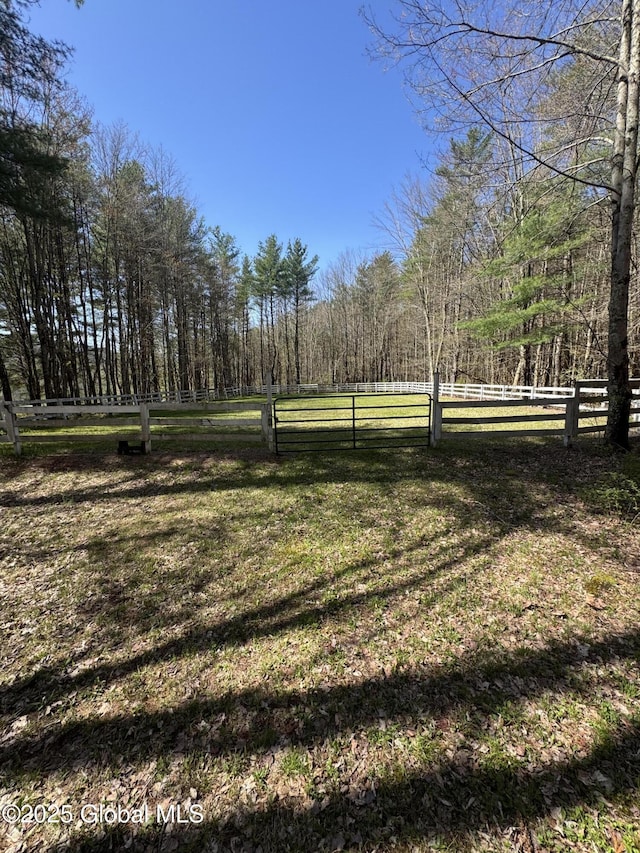view of yard with fence and a wooded view