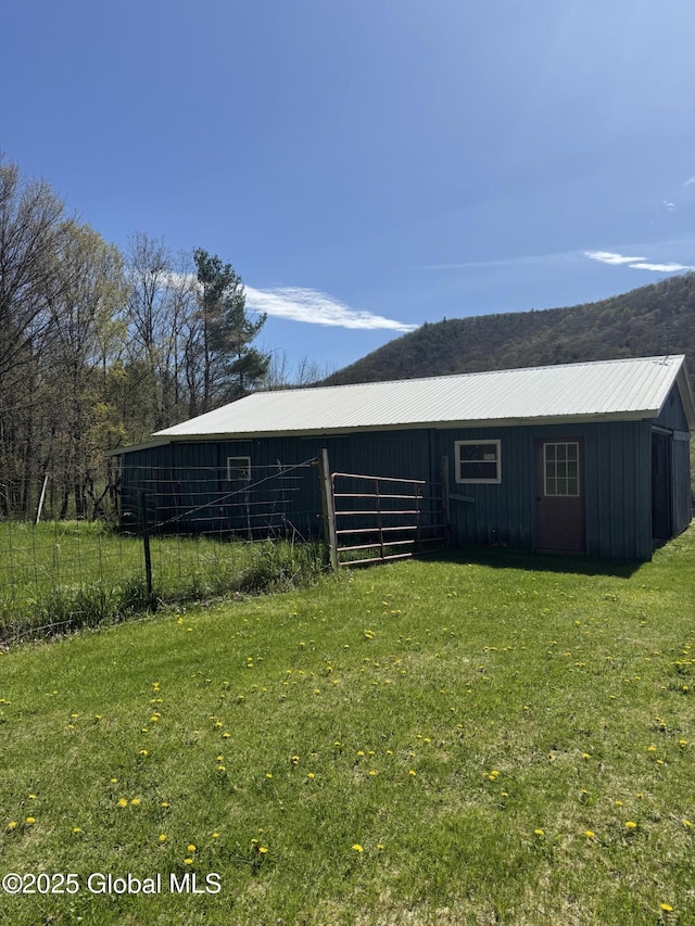 view of pole building featuring a lawn and fence