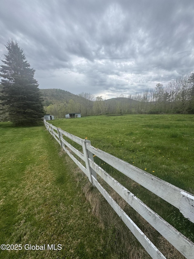 view of yard featuring fence and a rural view