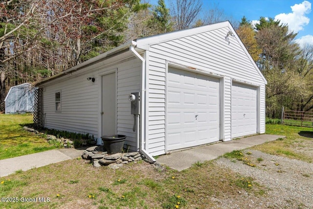 detached garage featuring fence