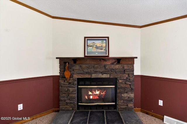 room details with visible vents, carpet flooring, wainscoting, and a stone fireplace