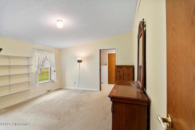 spare room with visible vents, lofted ceiling, baseboards, a textured ceiling, and carpet
