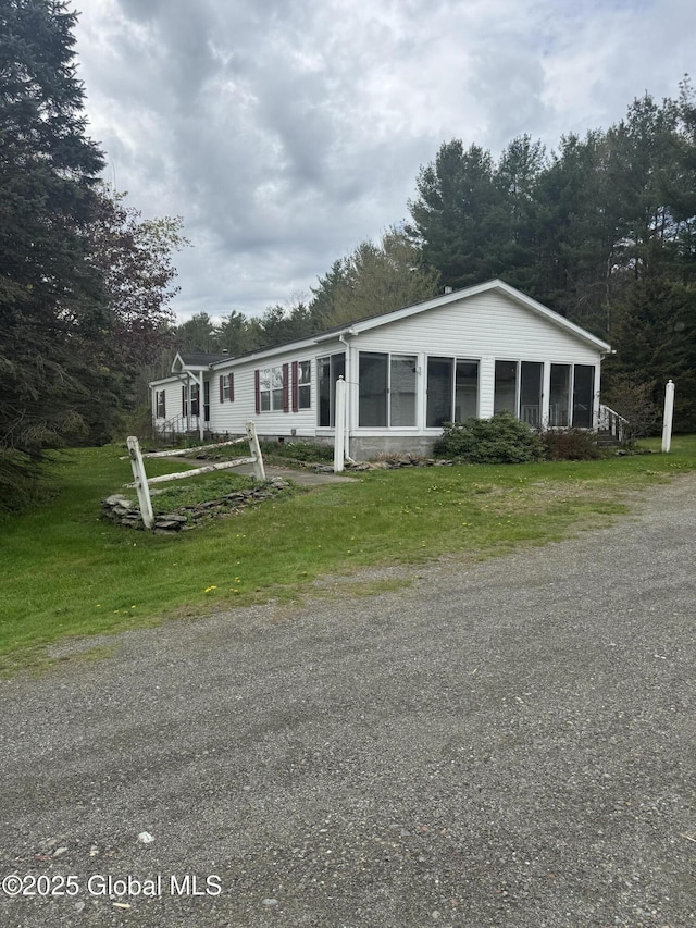 view of front of property with a sunroom and a front yard