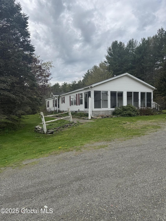 manufactured / mobile home featuring a front yard and a sunroom